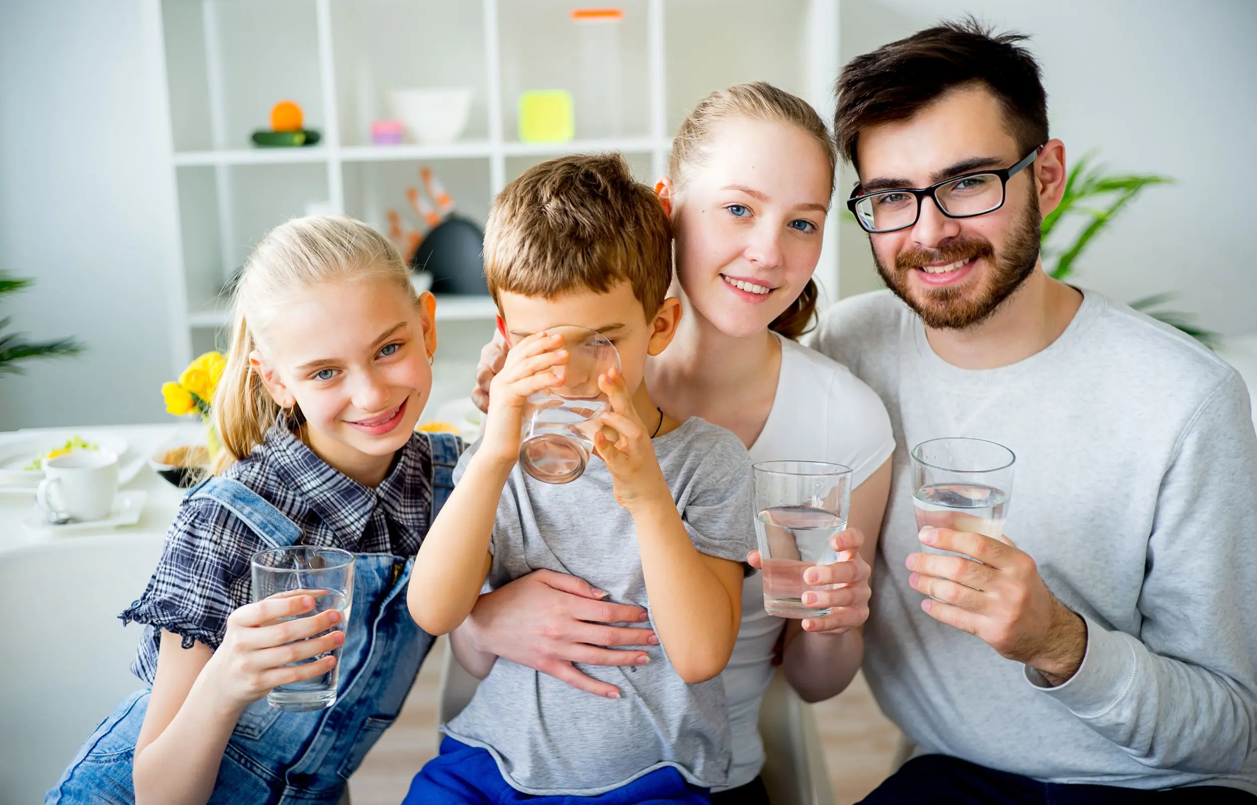 Smiling family holding water glasses - H2O to GO